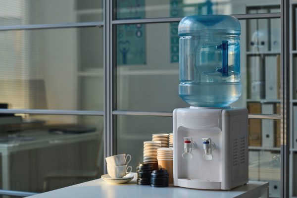 Place for coffee break in office with water and cups on table in modern office